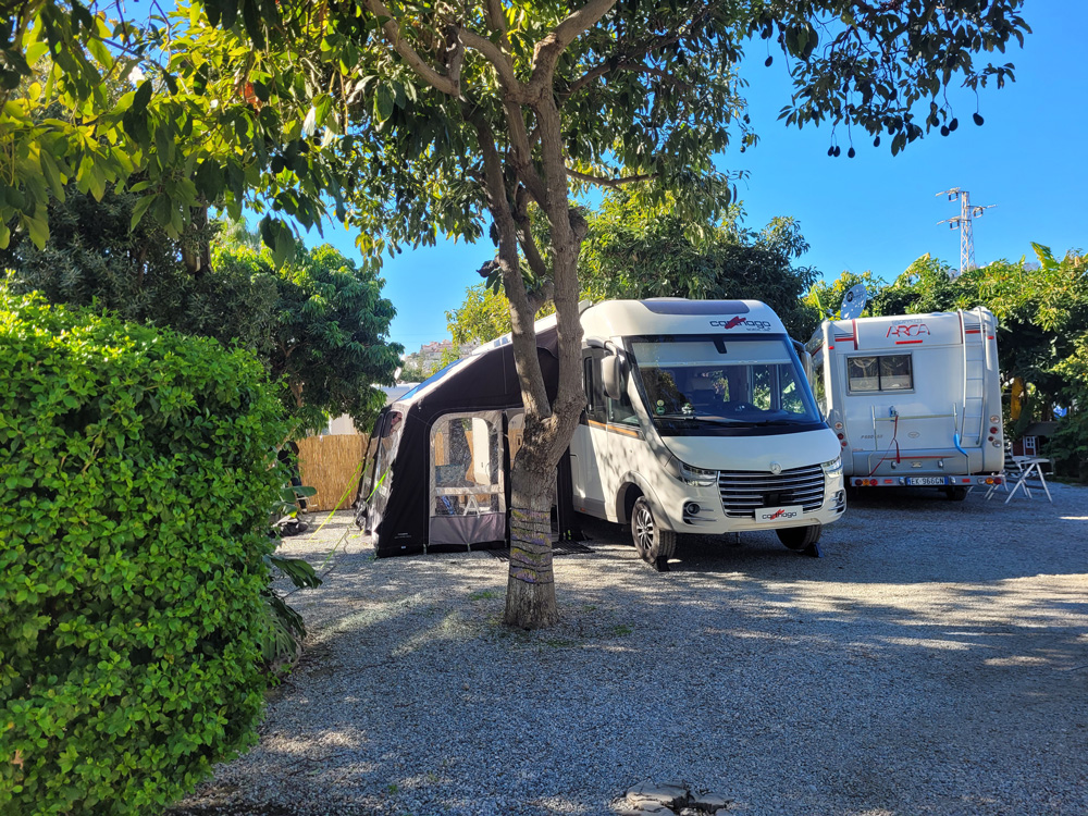 Husbil med förtält på grön camping i Europa, idealiskt för långtidscamping i Spanien