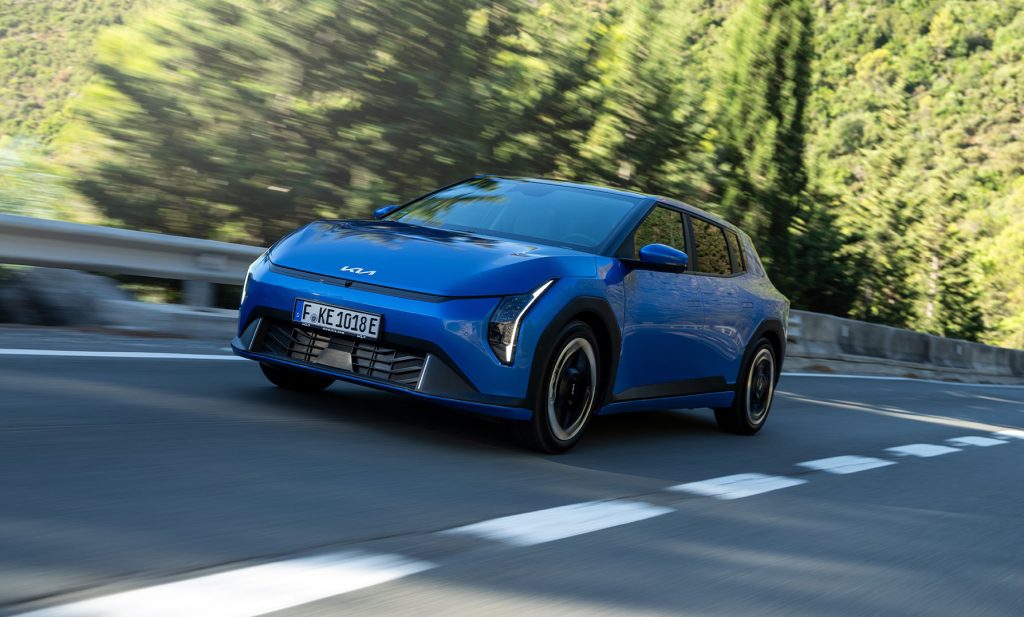 Blå Kia EV4 kör längs en landsväg – elbil med prestanda och stil för alla vägar.